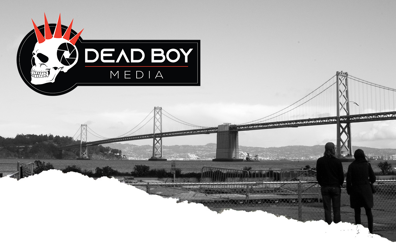 Black and white photo of a couple in front of a bridge with Dead Boy Media Logo.