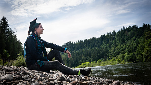 Graduation photo of a native woman in the woods.